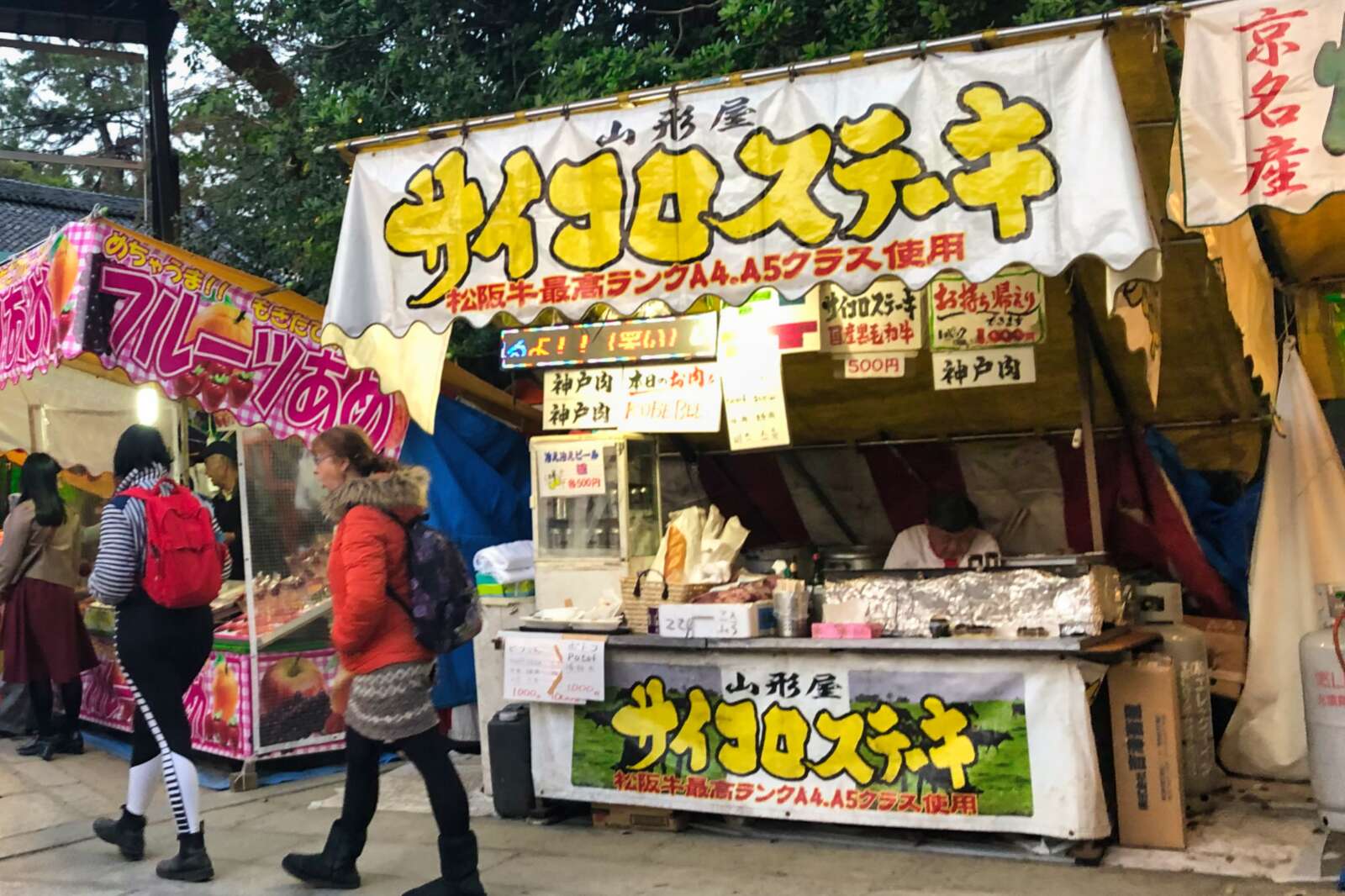 People walk by a food stand in Kyoto.