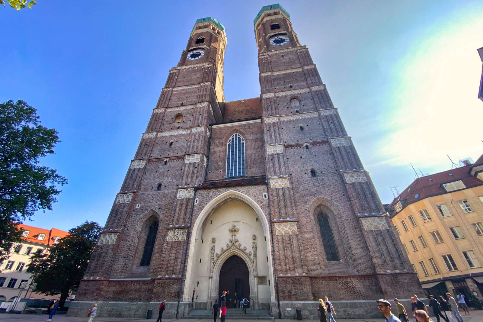 People in Munich, Germany walking by the Frauenkirche.