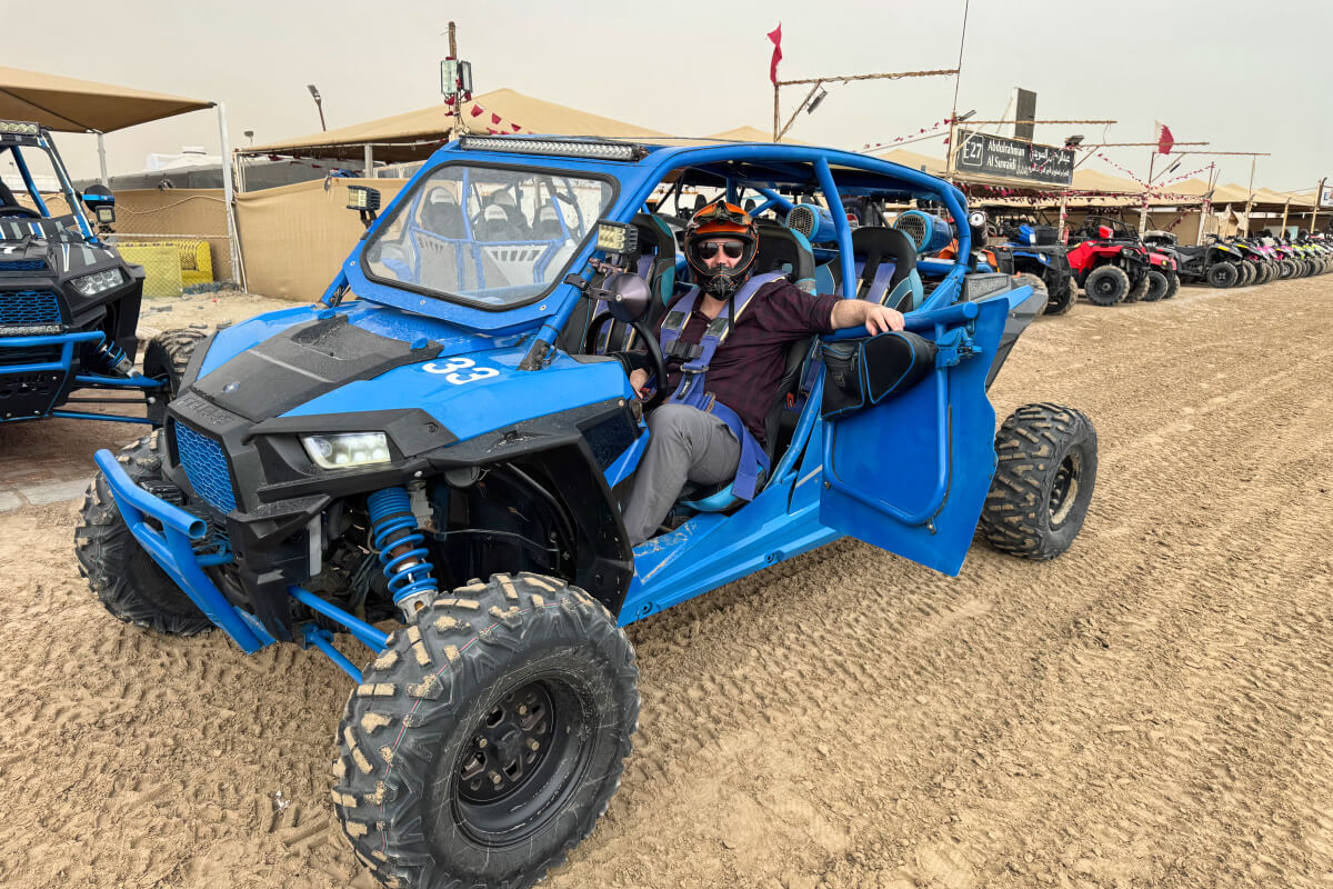 A photo of a person sitting in a dune buggy during a layover in Doha, Qatar.