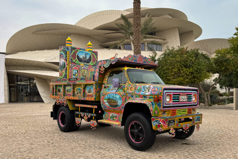 A decorated truck sits parked in front of the National Museum of Qatar.