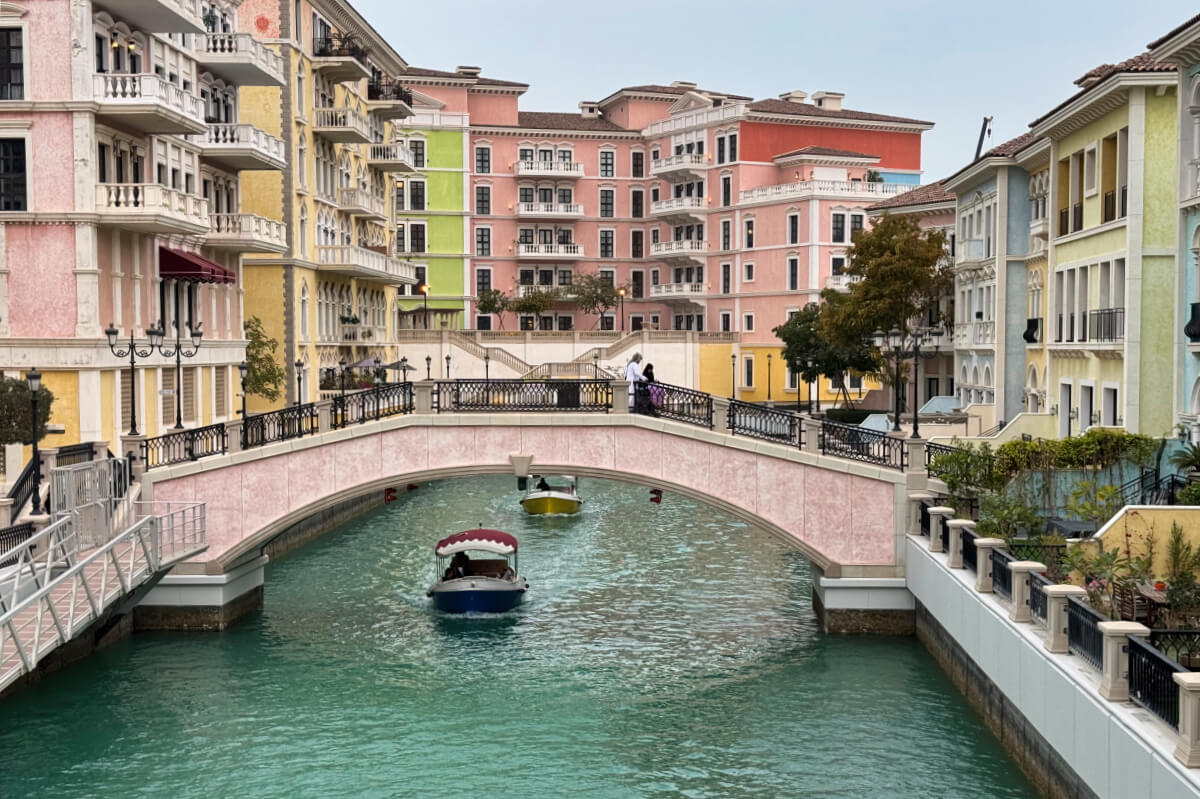 Boats pass under a bridge in the Little Italy area of Doha, Qatar.